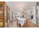 Formal dining room featuring hardwood floors, elegant chandelier, and open access to the foyer at 10458 Sw 52Nd Ct, Ocala, FL 34476