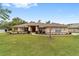 Charming single-story home with a manicured lawn, tasteful landscaping and a vibrant red front door at 10458 Sw 52Nd Ct, Ocala, FL 34476