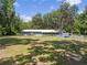Large, lush backyard with mature trees providing shade, home and outbuildings at 18341 Nw 142Nd Court Rd, Williston, FL 32696