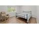 Neutral bedroom features a metal bed frame and a comfortable armchair for relaxation at 18341 Nw 142Nd Court Rd, Williston, FL 32696