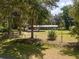 Exterior view of cozy home, framed by lush foliage, with expansive front yard and fencing at 18341 Nw 142Nd Court Rd, Williston, FL 32696