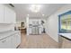 Open kitchen with stainless steel appliances, white cabinets, and a breakfast nook visible in the background at 18341 Nw 142Nd Court Rd, Williston, FL 32696