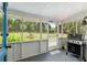 Relaxing screened porch with a grill, offering serene views of the lush backyard at 18341 Nw 142Nd Court Rd, Williston, FL 32696