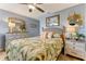 Cozy bedroom with light blue walls, stylish decor, and a comfortable bed with floral bedding at 1882 Royal Lytham Ct, Port Orange, FL 32128