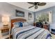 Comfortable bedroom with a ceiling fan and a desk area next to a window with plantation shutters at 1882 Royal Lytham Ct, Port Orange, FL 32128