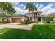 Charming two-story home with mature landscaping, lush green lawn, and an attached two-car garage at 1882 Royal Lytham Ct, Port Orange, FL 32128