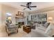 Cozy living room with a stone fireplace, neutral tones, and large windows offering plenty of natural light at 1882 Royal Lytham Ct, Port Orange, FL 32128
