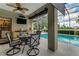 Undercover patio with a wet bar, dining table, and a pool behind a screen enclosure at 1882 Royal Lytham Ct, Port Orange, FL 32128