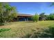 Spacious backyard featuring lush green grass, mature trees, and a cozy patio area, ideal for relaxation and recreation at 2030 Se 32Nd Ln, Ocala, FL 34471
