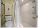 Bathroom with tiled walls and floor, featuring a corner shower with white curtain, and coordinating toilet with cabinet at 2030 Se 32Nd Ln, Ocala, FL 34471