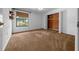 Bedroom featuring neutral walls and carpeting, with window view and closet with wood-paneled storage system at 2030 Se 32Nd Ln, Ocala, FL 34471