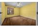 Bedroom featuring bright yellow walls and carpeting, with large window and ceiling fan with light at 2030 Se 32Nd Ln, Ocala, FL 34471