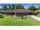 Charming single-story brick home featuring a well-manicured lawn and a welcoming red front door at 2030 Se 32Nd Ln, Ocala, FL 34471