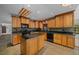 A gourmet kitchen with custom wood cabinets, a center island, black granite countertops and modern appliances at 2030 Se 32Nd Ln, Ocala, FL 34471