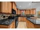 Spacious kitchen featuring granite countertops, custom wood cabinetry, and modern black appliances at 2030 Se 32Nd Ln, Ocala, FL 34471