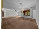 Spacious living room featuring plush carpeting, a decorative chandelier, and natural light through a large window at 2030 Se 32Nd Ln, Ocala, FL 34471