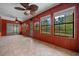 Inviting sunroom with multiple windows and a decorative ceiling fan, ideal for enjoying the outdoor view at 2030 Se 32Nd Ln, Ocala, FL 34471