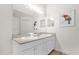 Bright bathroom with double vanity, neutral countertops, white cabinetry, and decorative mirror at 2950 Lucayan Harbour Cir # 107, Kissimmee, FL 34746