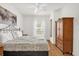 Bright bedroom features a decorative bed frame, wood floors, a ceiling fan, and a large armoire at 2950 Lucayan Harbour Cir # 107, Kissimmee, FL 34746