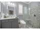 Modern bathroom with a walk-in glass shower, gray cabinets, mosaic tile accent wall, and bright vanity lighting at 7274 Sw 95Th Ave, Ocala, FL 34481