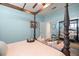 This bedroom features a four-poster bed, hardwood floors, light blue walls, and bright natural lighting at 7274 Sw 95Th Ave, Ocala, FL 34481