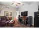 This room features hardwood floors, a ceiling fan, and a vintage entertainment center with a large TV at 7274 Sw 95Th Ave, Ocala, FL 34481