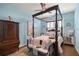 This bedroom boasts a four-poster bed, hardwood floors, ceiling fan, and bright natural lighting at 7274 Sw 95Th Ave, Ocala, FL 34481