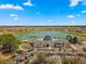 Aerial view of a stunning community clubhouse, a lake with a fountain, and ample parking amidst a golf course setting at 7274 Sw 95Th Ave, Ocala, FL 34481