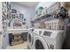The laundry room features front-loading washer and dryer, sink, and lots of wall decor and storage options at 7274 Sw 95Th Ave, Ocala, FL 34481
