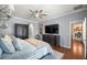 Comfortable primary bedroom with hardwood floors, with a TV, wardrobe, and access to the kitchen at 7274 Sw 95Th Ave, Ocala, FL 34481