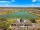 Aerial view of a community clubhouse overlooking a scenic pond with a fountain, surrounded by lush landscaping at 7274 Sw 95Th Ave, Ocala, FL 34481