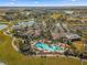 Aerial view of a community pool featuring palm trees, ample parking, and a clubhouse nestled within a well-maintained landscape at 7274 Sw 95Th Ave, Ocala, FL 34481