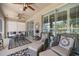 Relaxing screened porch featuring comfortable seating and ceiling fans at 7274 Sw 95Th Ave, Ocala, FL 34481
