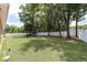 Expansive backyard featuring a well-maintained lawn, mature trees, and a white fence for privacy at 2648 Ne 24Th Pl, Ocala, FL 34470