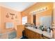 Bright bathroom featuring a white sink, oak cabinets, large mirror, and a separate tub area at 2648 Ne 24Th Pl, Ocala, FL 34470