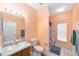 Bright bathroom with neutral tile flooring, large mirror, and a separate shower and toilet area at 2648 Ne 24Th Pl, Ocala, FL 34470