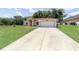 Exterior view of a single-story home with well-maintained lawn and paved driveway leading to the garage at 2648 Ne 24Th Pl, Ocala, FL 34470