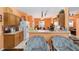 Bright kitchen with wooden cabinets, breakfast bar, white appliances, and an easy transition to the dining area at 2648 Ne 24Th Pl, Ocala, FL 34470