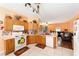 Open kitchen with wooden cabinets, a white stove and seamless access to a comfortable adjacent living room at 2648 Ne 24Th Pl, Ocala, FL 34470