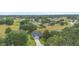 Aerial view of a charming home with a well-manicured lawn and mature trees in a friendly neighborhood at 23510 Oak Prairie Cir, Sorrento, FL 32776