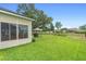 Fenced backyard featuring lush lawn, patio with hot tub, gazebo with grill, and mature trees at 23510 Oak Prairie Cir, Sorrento, FL 32776