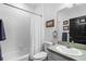 Bright bathroom with tiled shower and tub, white cabinets, and a modern sink at 23510 Oak Prairie Cir, Sorrento, FL 32776