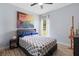 Well-lit bedroom with modern decor, large windows, light blue walls, and wood-look tile flooring at 23510 Oak Prairie Cir, Sorrento, FL 32776