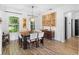 Bright dining room features a dark wood table, chandelier, wood-look flooring and neutral walls at 23510 Oak Prairie Cir, Sorrento, FL 32776