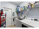 Bright laundry room features a washer, dryer, utility sink, shelving and a white door at 23510 Oak Prairie Cir, Sorrento, FL 32776