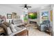 Bright living room features a stone fireplace, recessed lighting, neutral walls, and wood look flooring at 23510 Oak Prairie Cir, Sorrento, FL 32776