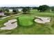 Aerial view of a golf course putting green surrounded by sand traps and lush greenery at 5237 Nw 48Th Pl, Ocala, FL 34482