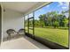 Covered lanai with seating overlooking a large, well-maintained backyard and garden at 5237 Nw 48Th Pl, Ocala, FL 34482
