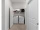 Clean laundry room with washer, dryer, storage shelves, and easy access from hallway at 5237 Nw 48Th Pl, Ocala, FL 34482