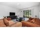 Open-concept living room with a large couch, media center, and access to screened-in lanai at 5237 Nw 48Th Pl, Ocala, FL 34482
